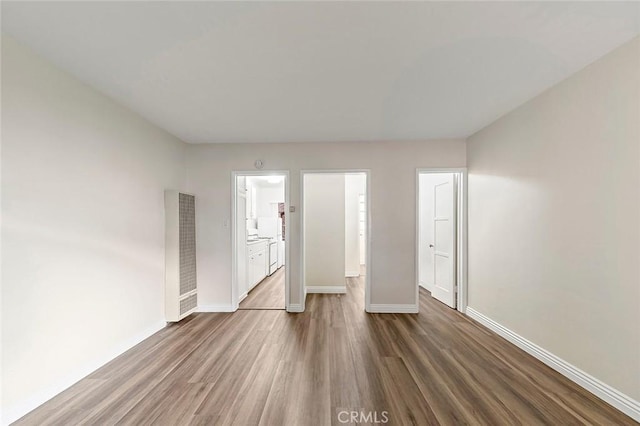 unfurnished bedroom featuring ensuite bath, a closet, and dark hardwood / wood-style floors