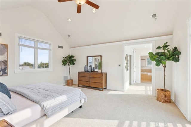 bedroom with ceiling fan, high vaulted ceiling, light carpet, and ensuite bath