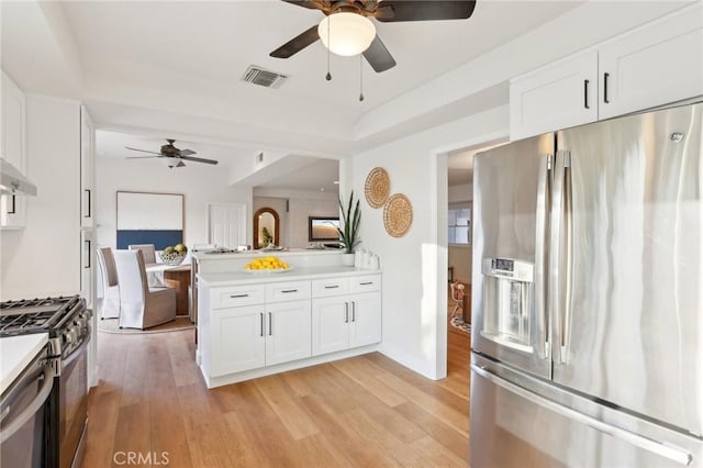 kitchen featuring light wood-type flooring, ceiling fan, white cabinetry, and appliances with stainless steel finishes