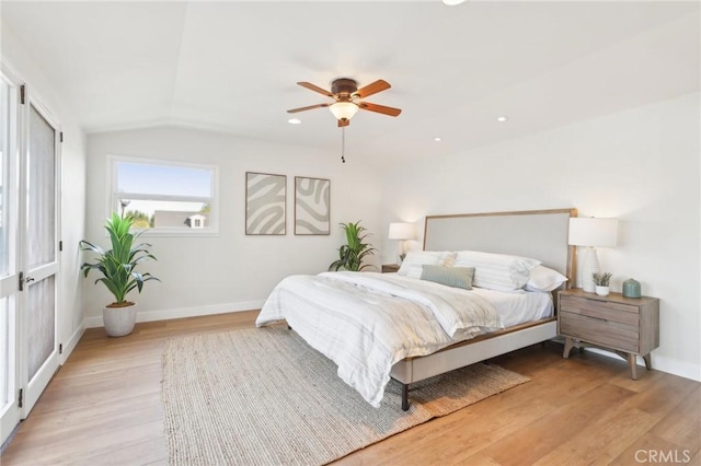 bedroom featuring ceiling fan, light hardwood / wood-style floors, and lofted ceiling