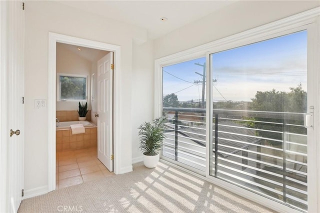 doorway to outside with light tile patterned flooring and a wealth of natural light