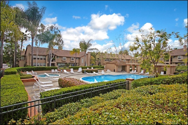 view of pool with a hot tub and a patio area