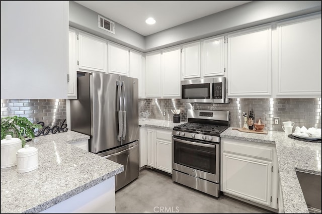 kitchen featuring white cabinetry, appliances with stainless steel finishes, and tasteful backsplash