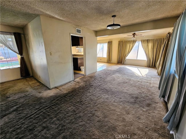 carpeted empty room featuring a textured ceiling and ceiling fan