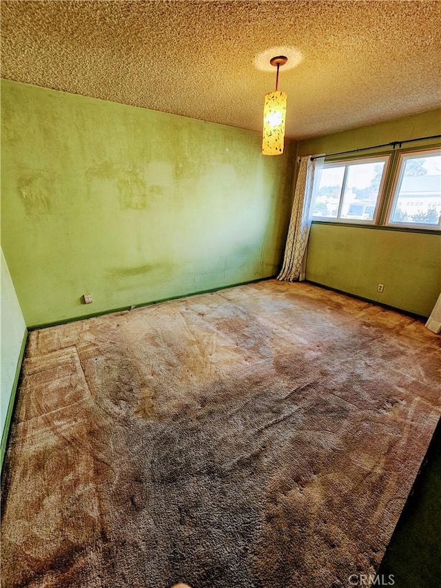 carpeted spare room featuring a textured ceiling