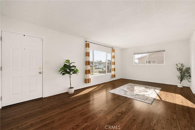 entrance foyer with dark hardwood / wood-style flooring and a textured ceiling