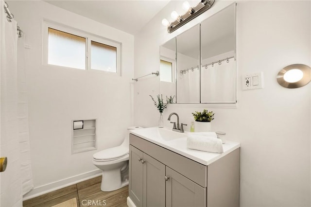 bathroom featuring wood-type flooring, vanity, and toilet