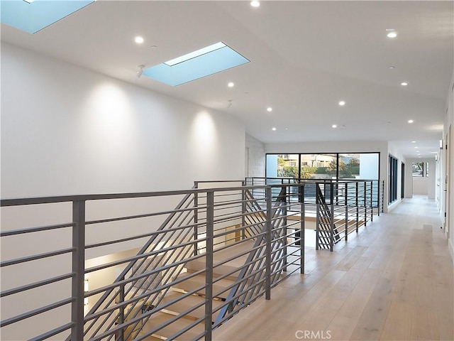 corridor featuring light hardwood / wood-style flooring and a skylight