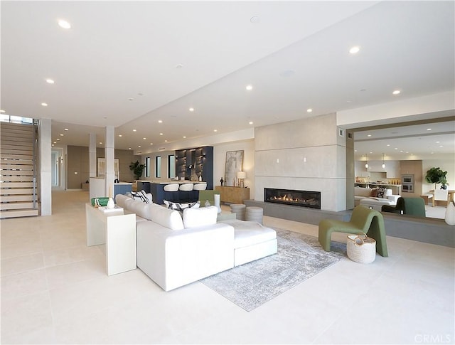 living room with a tile fireplace and light tile patterned flooring