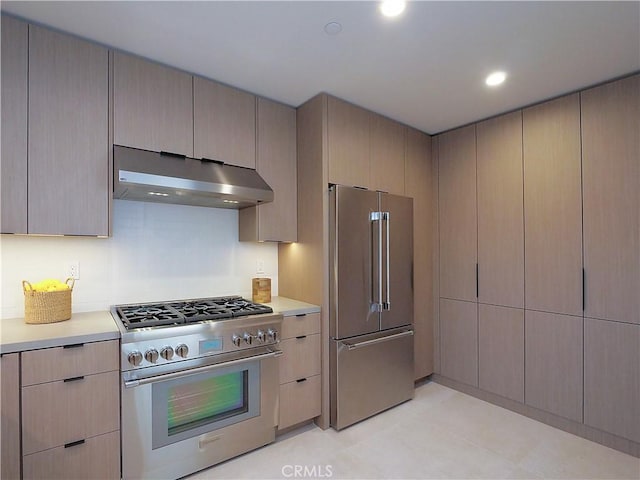 kitchen with high end appliances, light brown cabinetry, and extractor fan