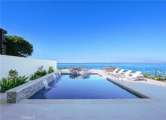 view of swimming pool with a patio, a water view, and pool water feature