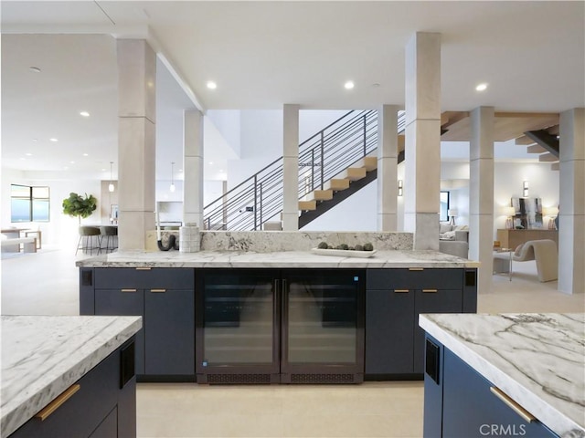 kitchen featuring light stone counters, beverage cooler, and a healthy amount of sunlight