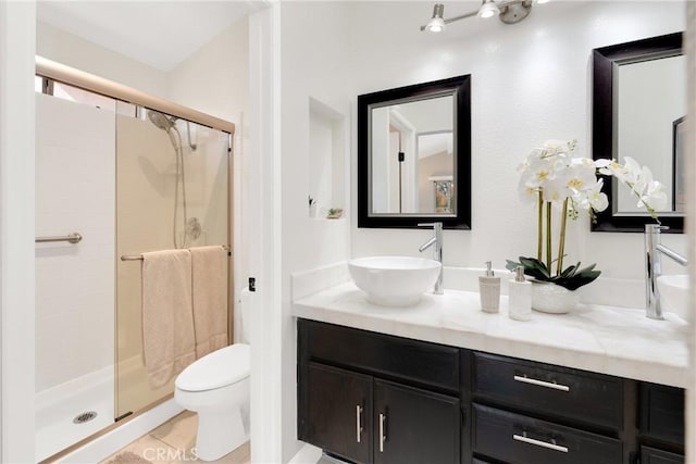 bathroom with tile patterned floors, vanity, toilet, and walk in shower