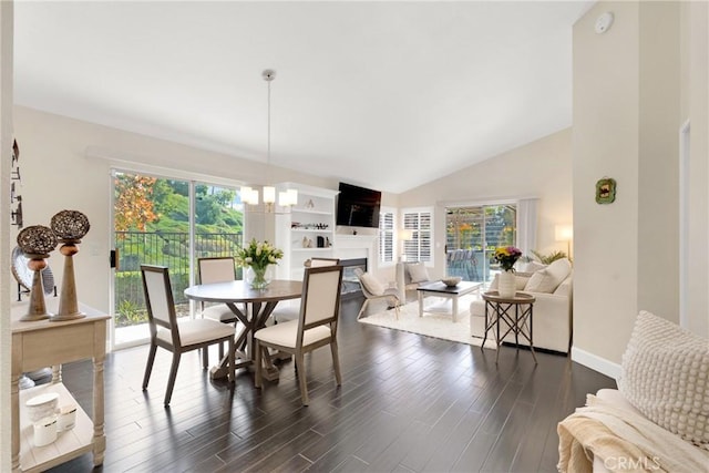 dining area featuring an inviting chandelier, dark wood-type flooring, a wealth of natural light, and vaulted ceiling