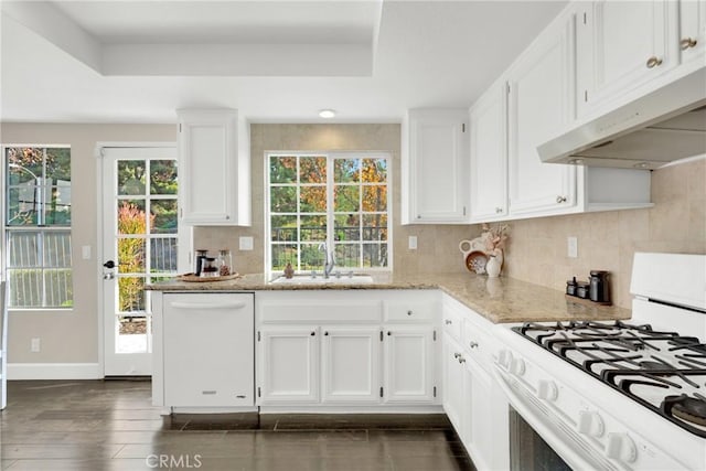 kitchen featuring decorative backsplash, light stone counters, white appliances, sink, and white cabinetry