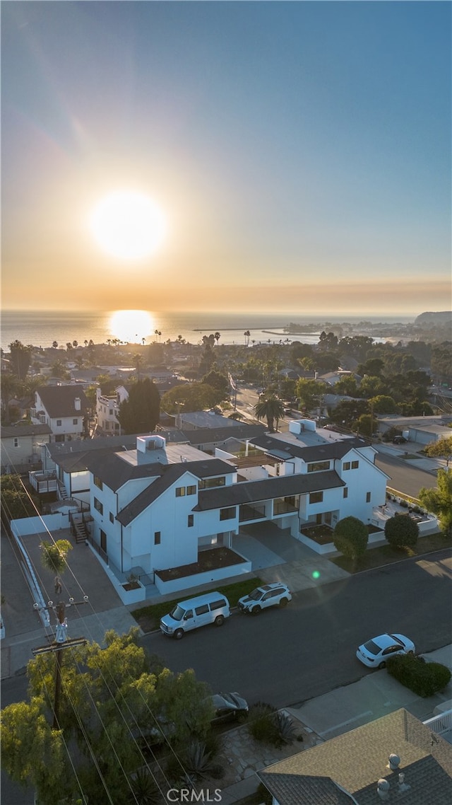 aerial view at dusk featuring a water view