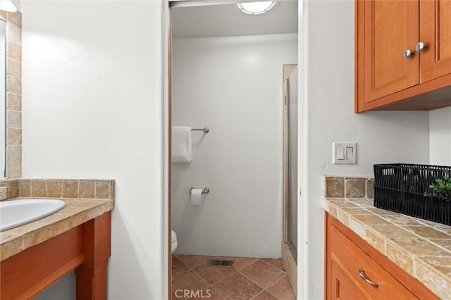 bathroom featuring toilet, walk in shower, and sink