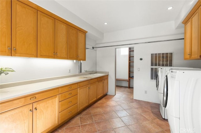 laundry area with washer and clothes dryer, cabinets, and sink