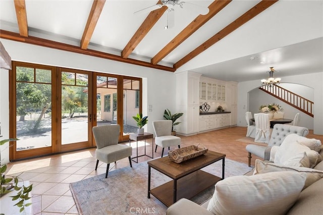 tiled living room featuring french doors, ceiling fan with notable chandelier, high vaulted ceiling, and plenty of natural light