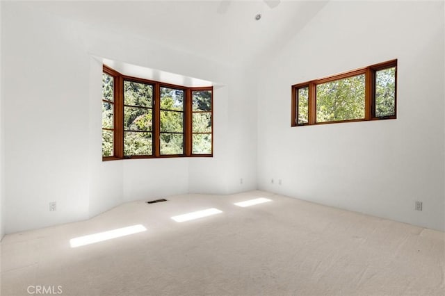 unfurnished room featuring carpet flooring and lofted ceiling