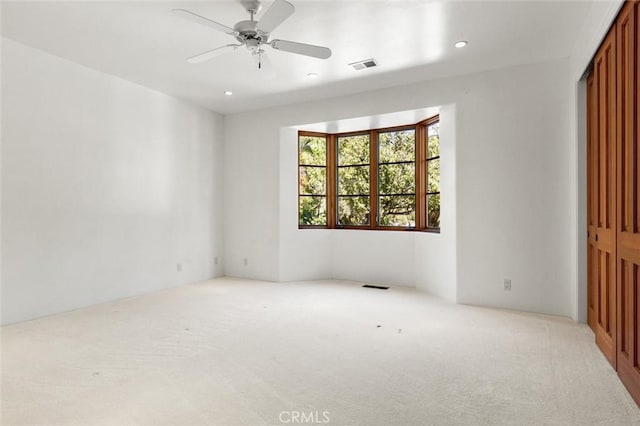 unfurnished room featuring ceiling fan and light carpet