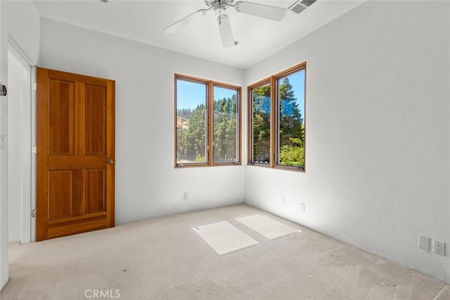 spare room with ceiling fan and light colored carpet