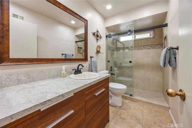 bathroom with tile patterned floors, vanity, an enclosed shower, and toilet