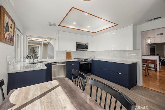 kitchen featuring light hardwood / wood-style floors, sink, white cabinetry, and stainless steel appliances