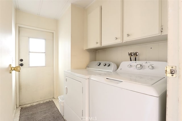 washroom with washer and dryer and cabinets