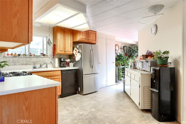 kitchen with backsplash, stainless steel appliances, and sink