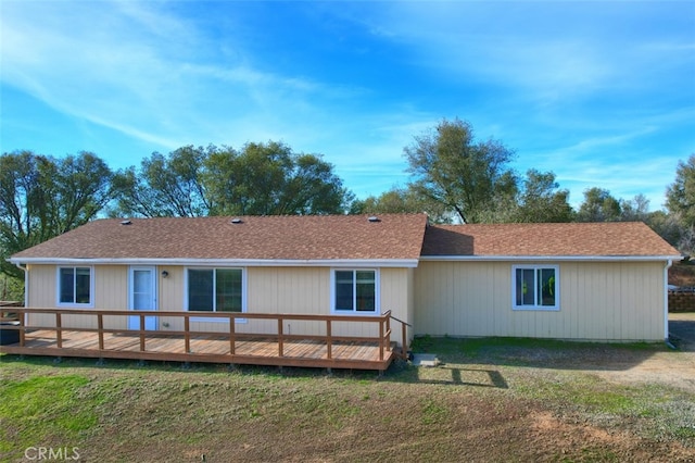 rear view of property with a yard and a deck