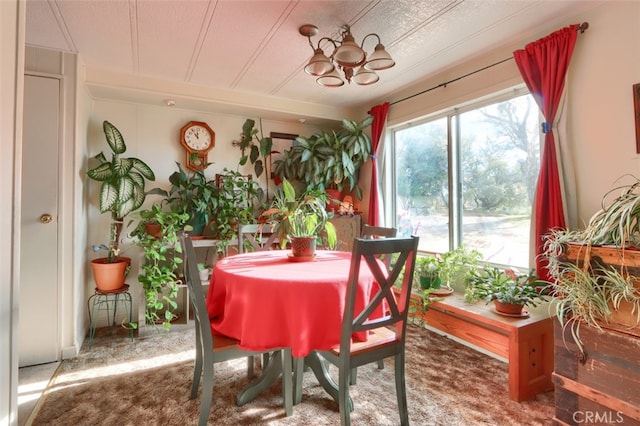 sunroom / solarium featuring a chandelier