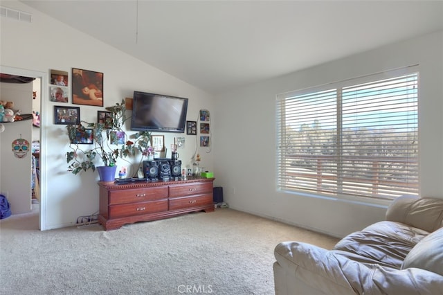 carpeted living room with plenty of natural light and lofted ceiling