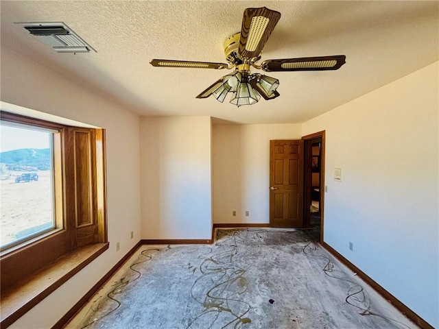 spare room with a textured ceiling and ceiling fan