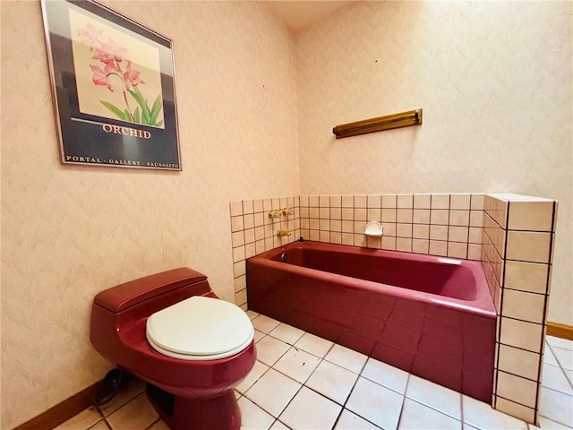 bathroom featuring a tub to relax in, tile patterned floors, and toilet