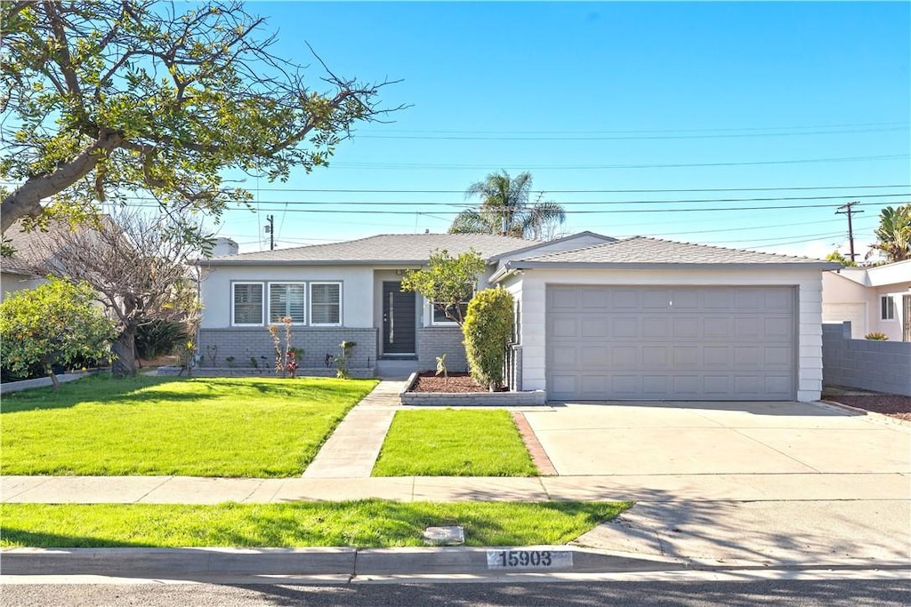 single story home featuring a garage and a front lawn