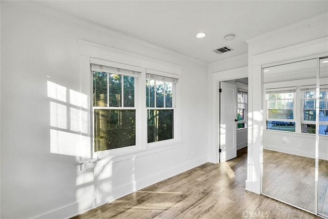 interior space with crown molding, a healthy amount of sunlight, and hardwood / wood-style floors