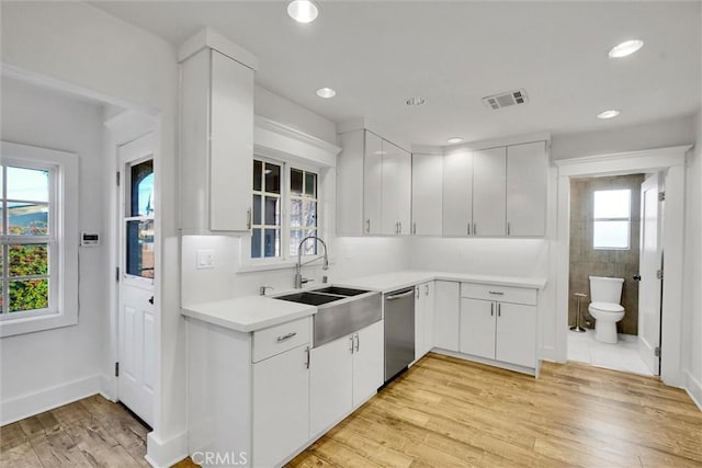 kitchen with sink, light hardwood / wood-style floors, white cabinets, and dishwasher