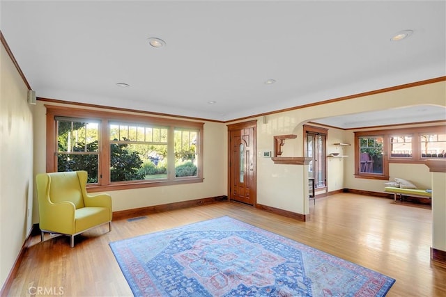 sitting room featuring light wood-type flooring and crown molding