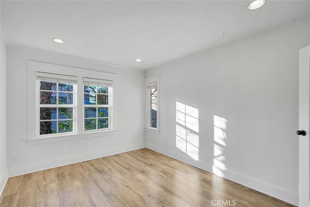 empty room with ornamental molding and light hardwood / wood-style flooring