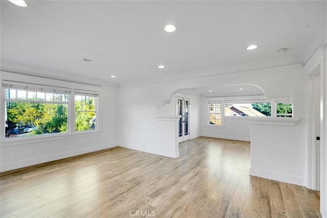 unfurnished living room with ornamental molding and light hardwood / wood-style floors