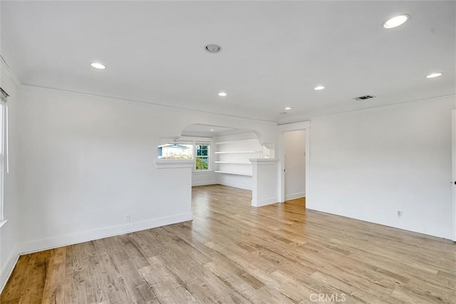 interior space featuring crown molding, built in features, and light hardwood / wood-style flooring