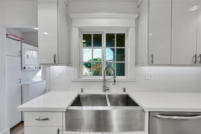 kitchen featuring sink, white cabinetry, dishwasher, hardwood / wood-style floors, and stacked washer and dryer