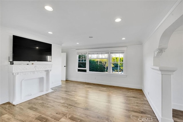 unfurnished living room with ornamental molding and wood-type flooring