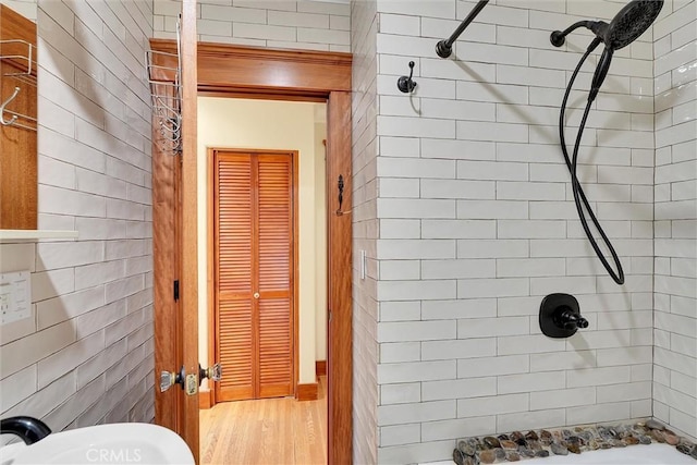 bathroom featuring sink, tiled shower, and hardwood / wood-style floors