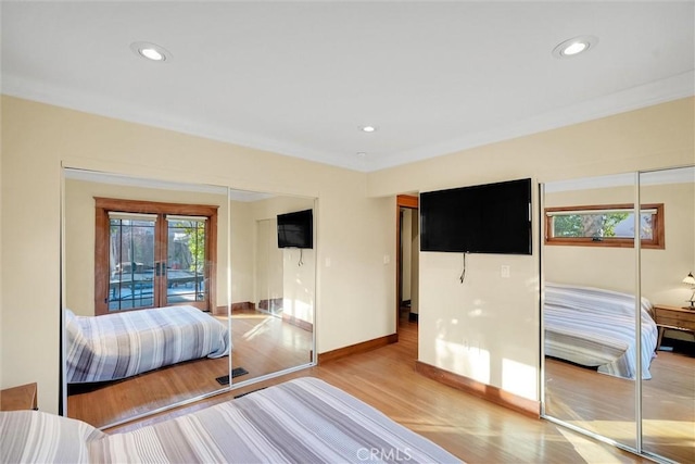 bedroom with light hardwood / wood-style floors, french doors, and crown molding