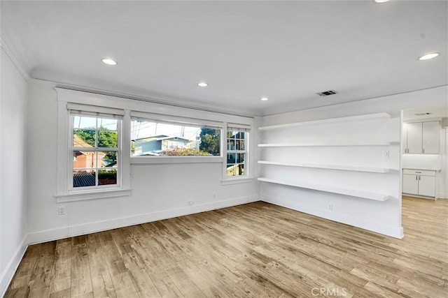 unfurnished room with crown molding and light hardwood / wood-style flooring