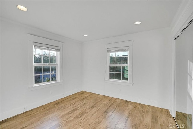 unfurnished room featuring ornamental molding, light hardwood / wood-style floors, and a healthy amount of sunlight