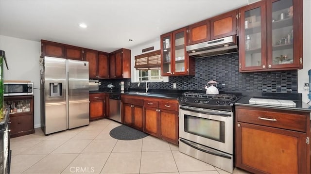 kitchen featuring decorative backsplash, light tile patterned floors, stainless steel appliances, and sink