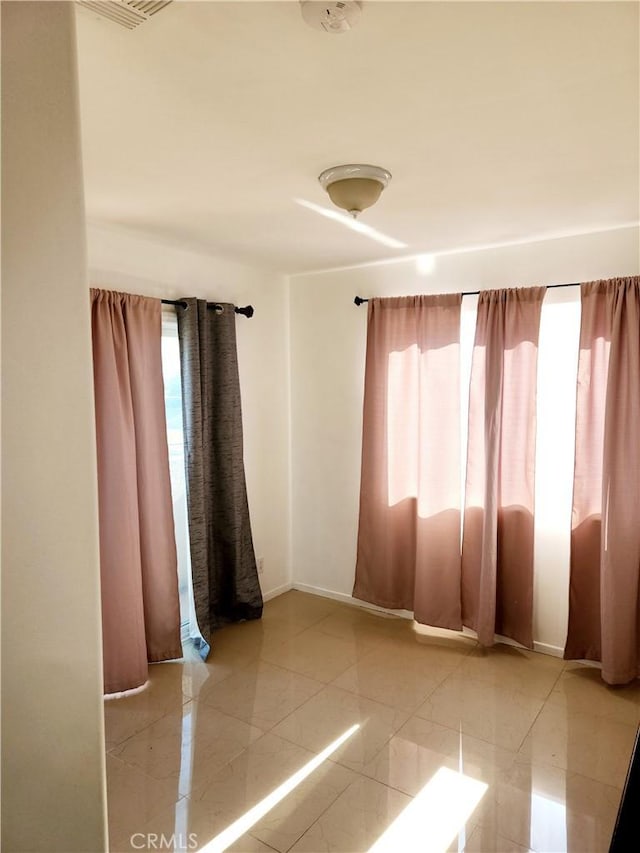 unfurnished room featuring light tile patterned flooring